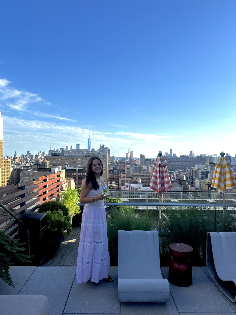 Sydney Holzman standing on a rooftop in New York City.
